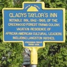 Metal sign marking the location of Gladys Taylor's Inn.