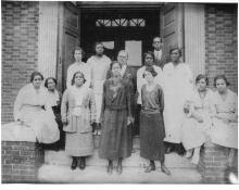 Teachers standing in front of Stanton School auditorium at Wright's Hotel